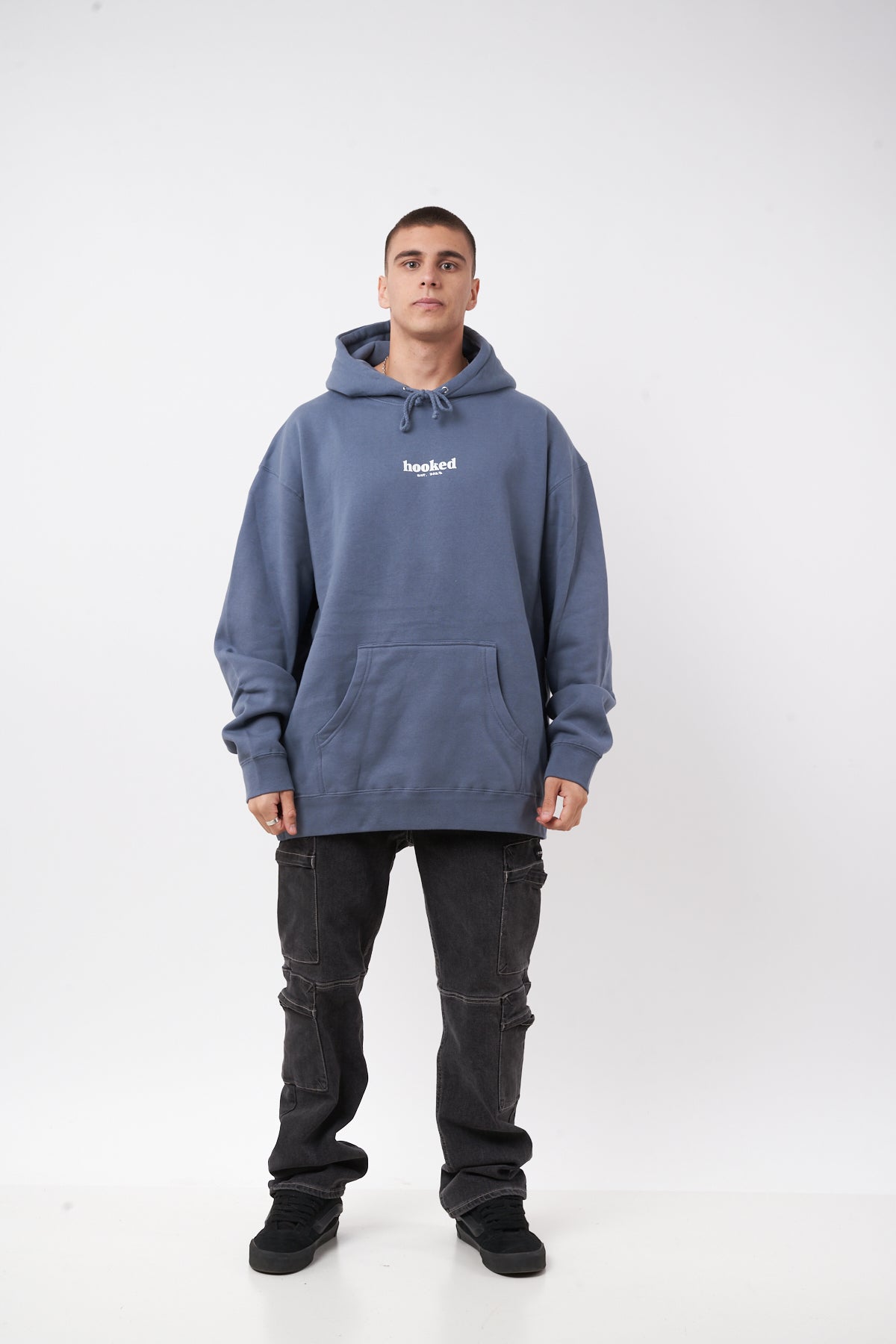 Person wearing a blue hoodie with a brand logo on a white background