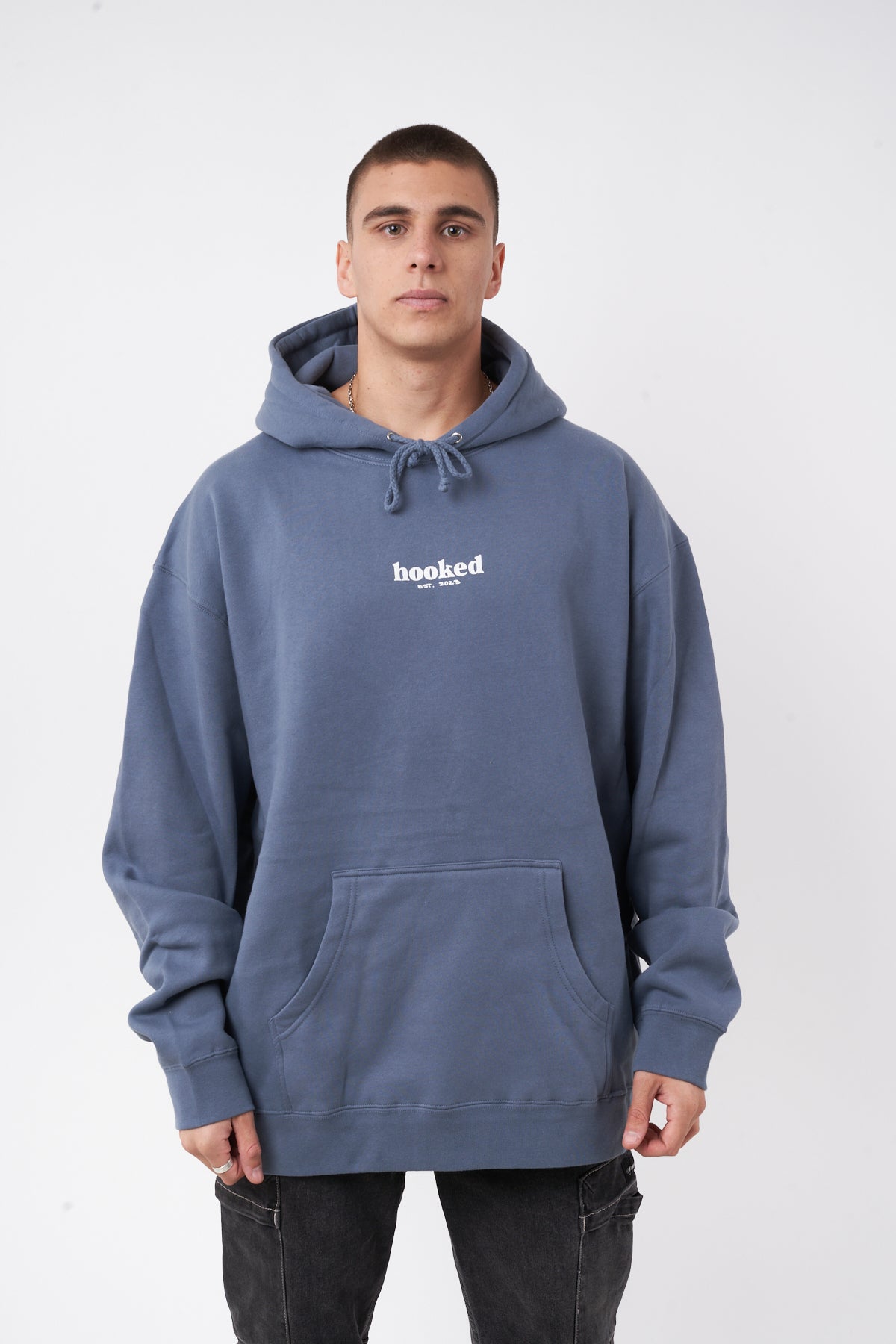 Man wearing a blue hoodie with 'hooked' logo on a white background