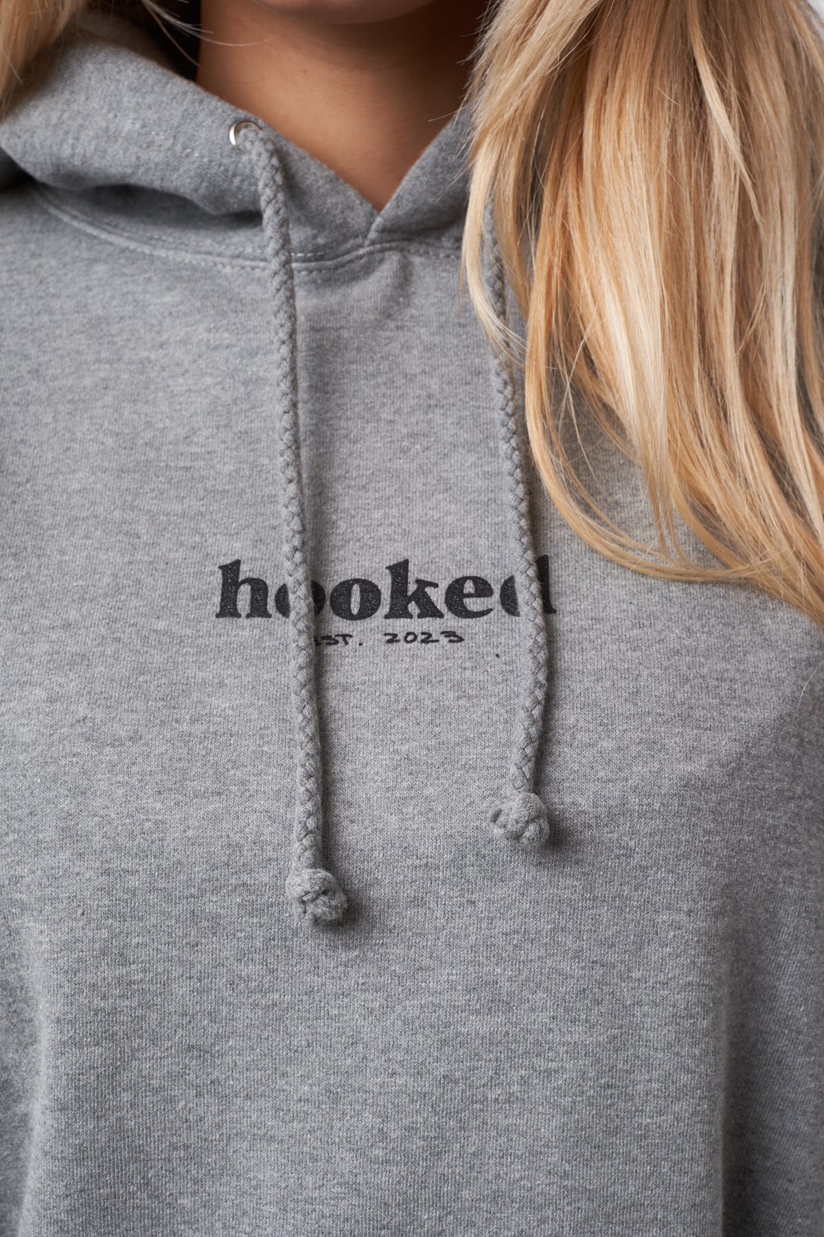Gray hoodie with 'hooked' logo on a blurred background