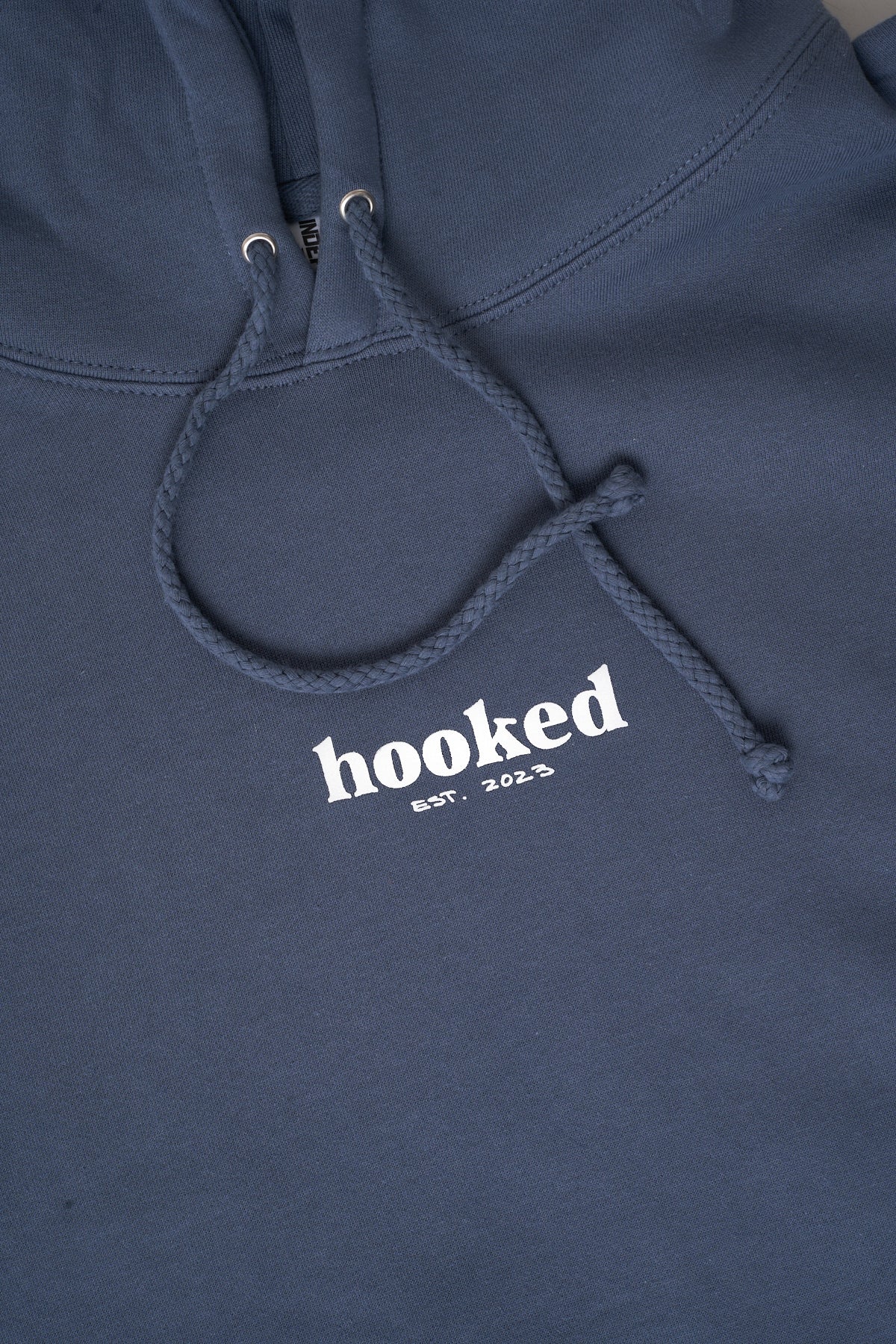 Light blue hoodie with 'hooked est. 2023' text on a dark background